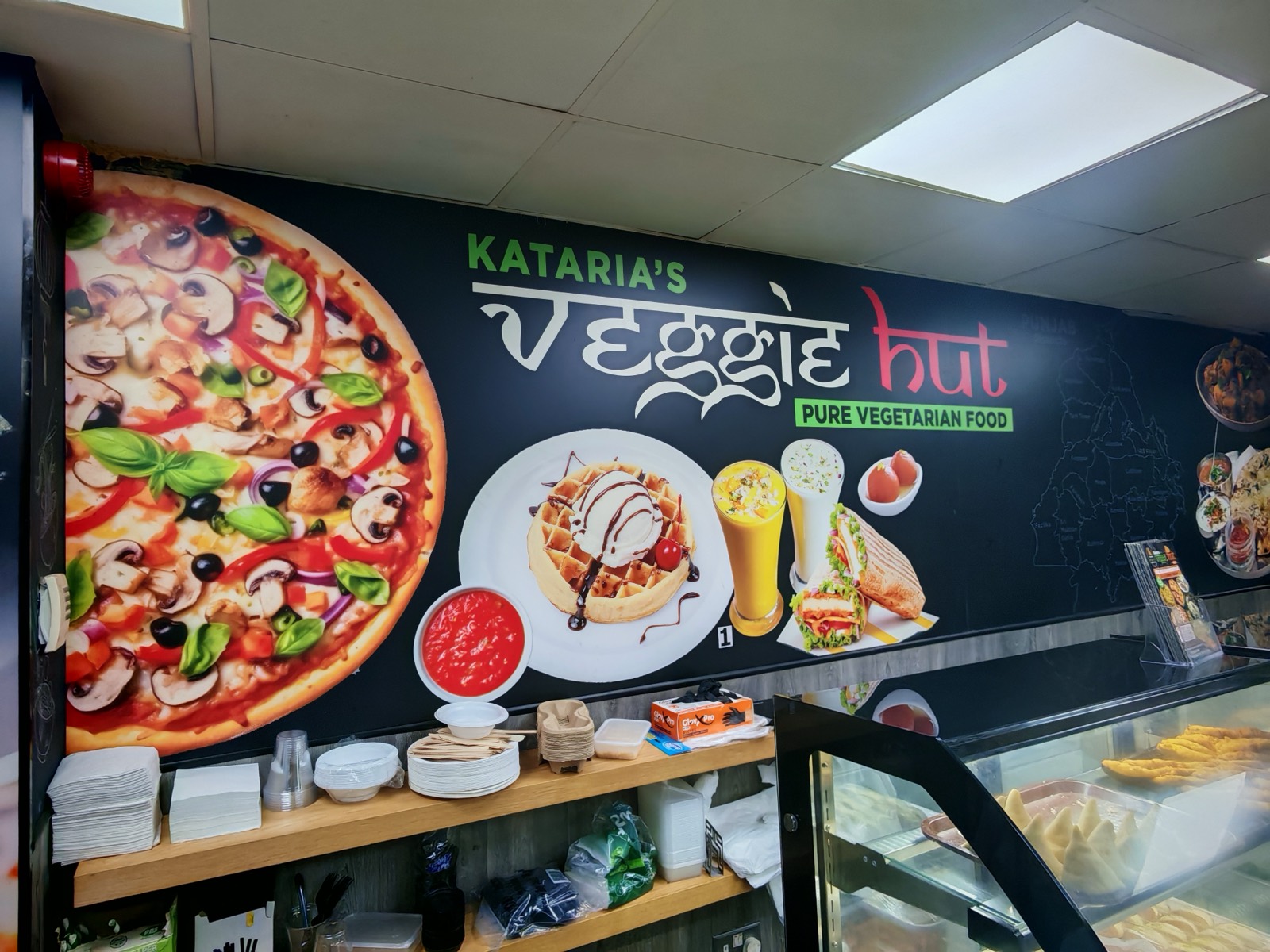 Counter and pizza mural inside the shop