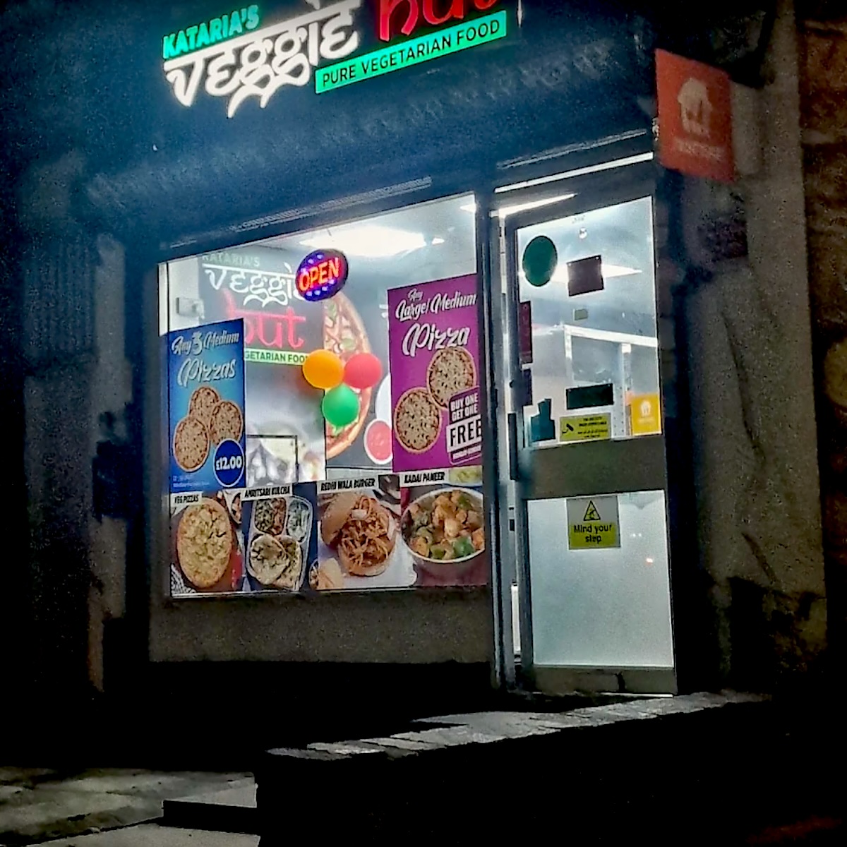 Kataria's Veggie Hut shopfront on Green Lane Road, lit up at night